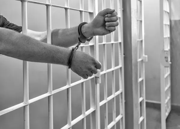 depositphotos_29992139-stock-photo-prisoner-in-handcuffs-locked-in (2)